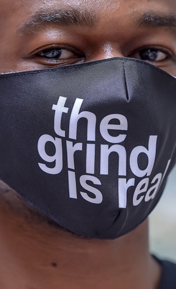 Model wearing the Grind is Real face mask from our Insert Coin collection