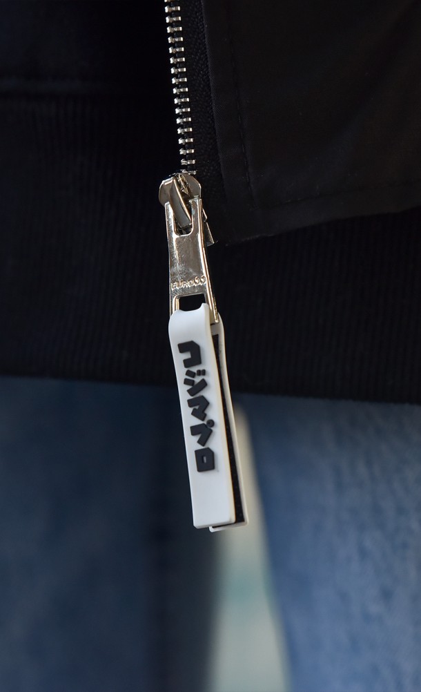 Close up detail on zip tag of the Hideo Kojima Bomber jacket from our Kojima Productions collection